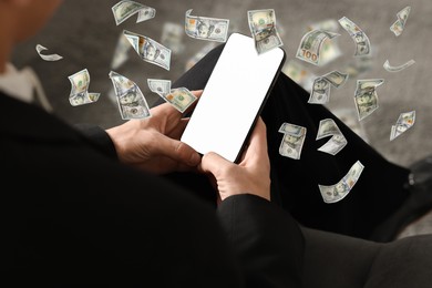 Image of Man using smartphone at home, closeup. Money flying around device