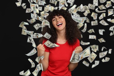 Happy woman under money rain on black background