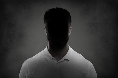 Image of Anonymous person. Shaded portrait of man on grey gradient background