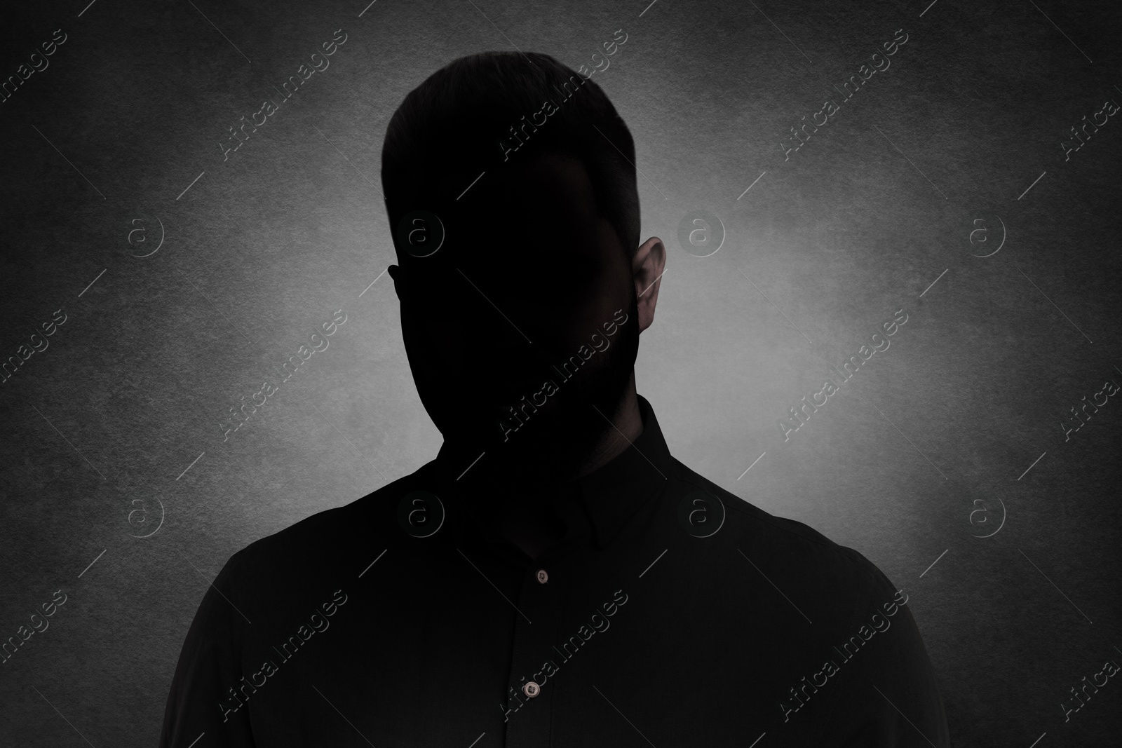 Image of Anonymous person. Shaded portrait of man on grey gradient background