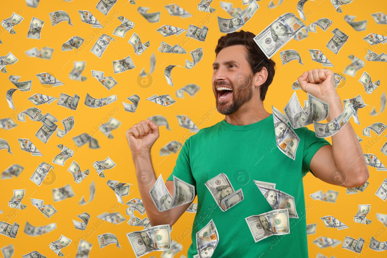 Image of Happy man under money rain on orange background