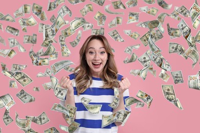 Happy woman under money rain on pink background