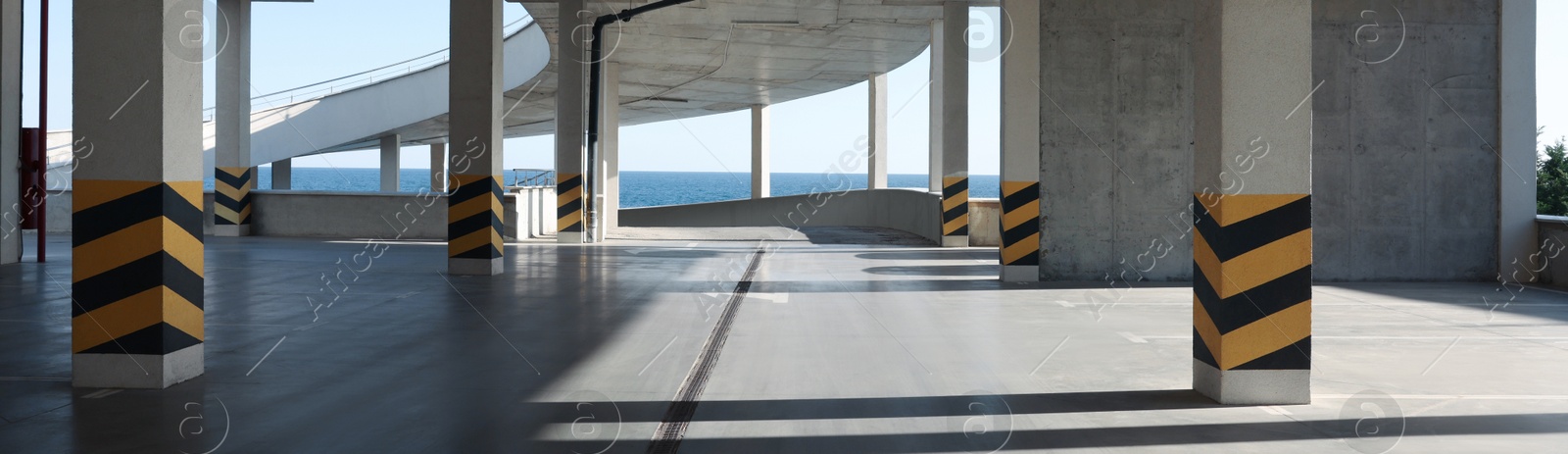 Image of Empty open car parking near sea on sunny day, banner design