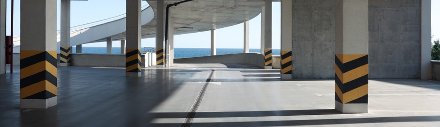 Empty open car parking near sea on sunny day, banner design