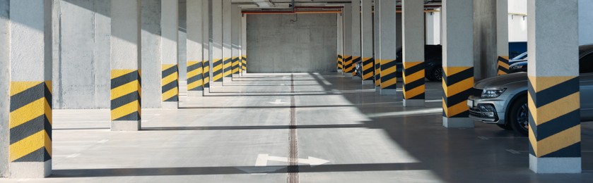 Open parking garage with cars on sunny day, banner design