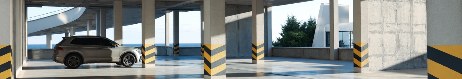 Image of Open parking garage with car on sunny day, banner design