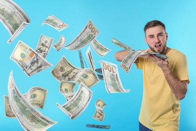 Image of Man throwing money on light blue background. Dollar bills flying away from him