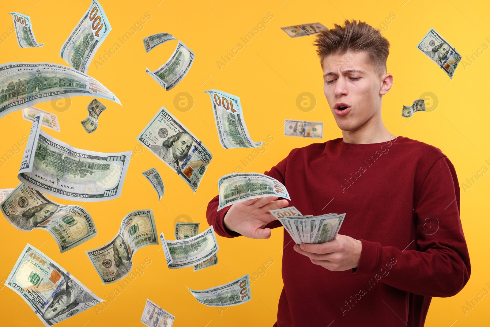 Image of Man throwing money on orange background. Dollar bills in air