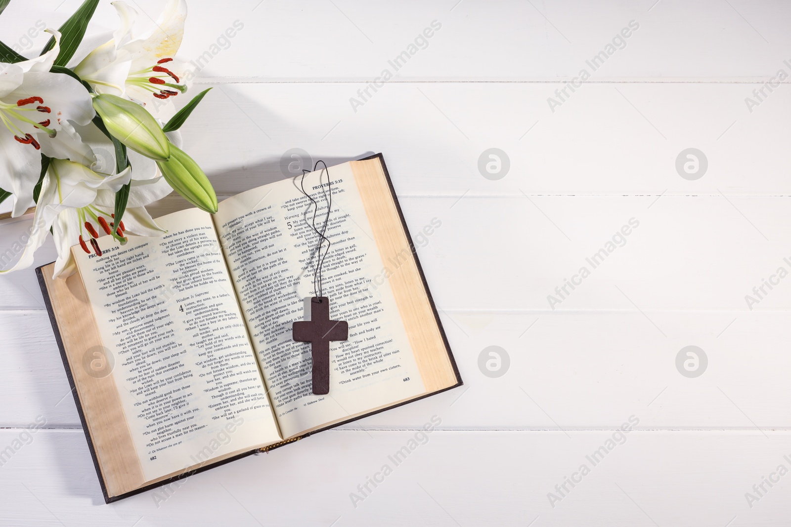 Photo of Cross, Bible and beautiful lily flowers on white wooden table, flat lay with space for text. Religion of Christianity