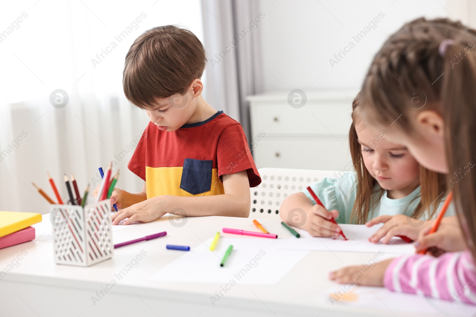 Photo of Group of children drawing at table indoors