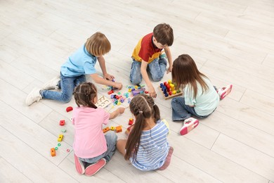 Photo of Group of children playing together on floor indoors