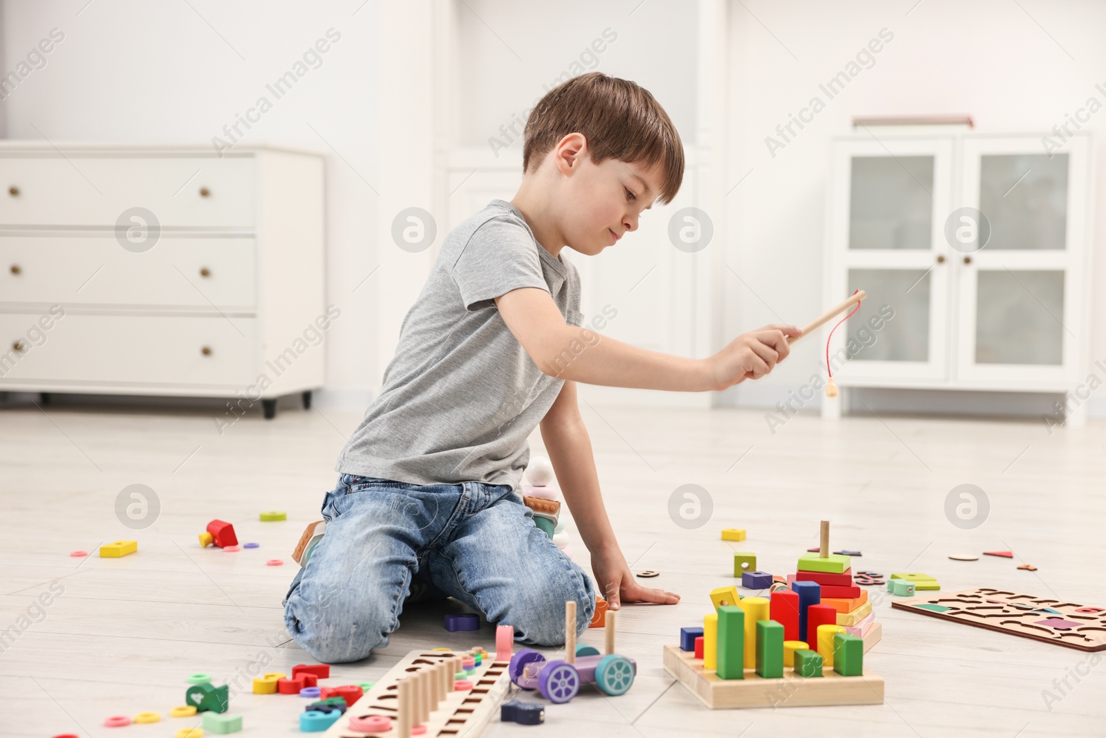 Photo of Cute little boy playing on floor indoors