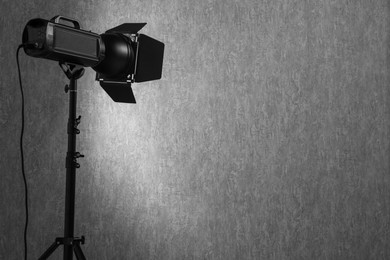 Grey photo background and professional lighting equipment in studio, space for text