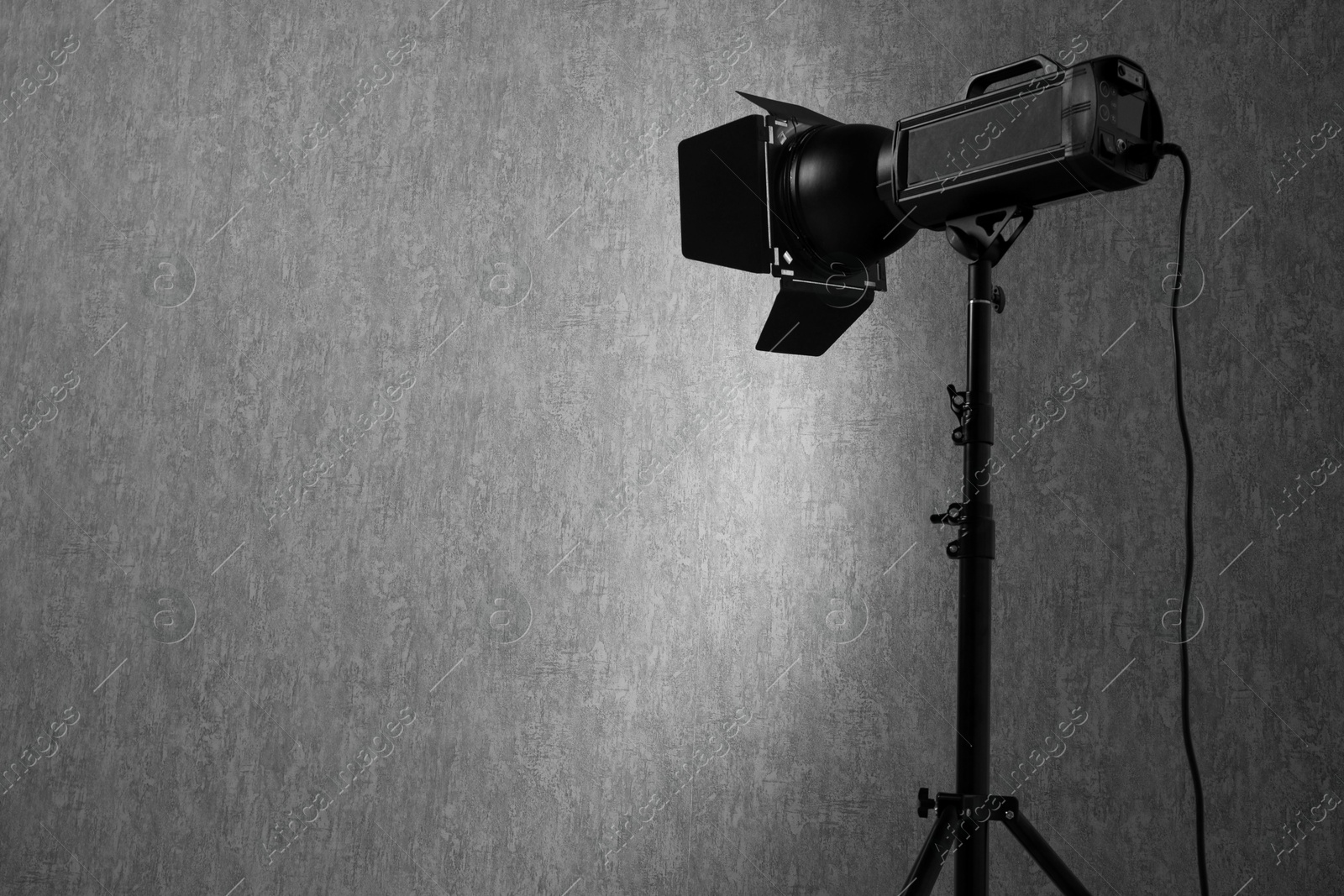 Photo of Grey photo background and professional lighting equipment in studio, space for text