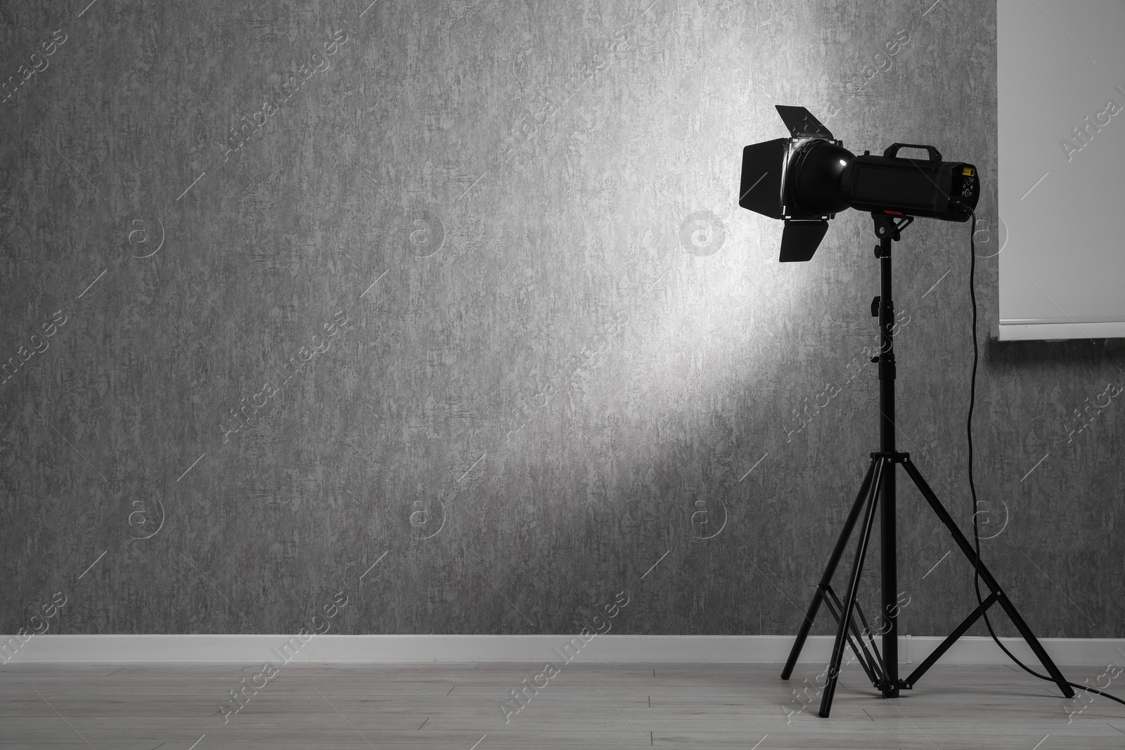 Photo of Grey photo background and professional lighting equipment in studio, space for text