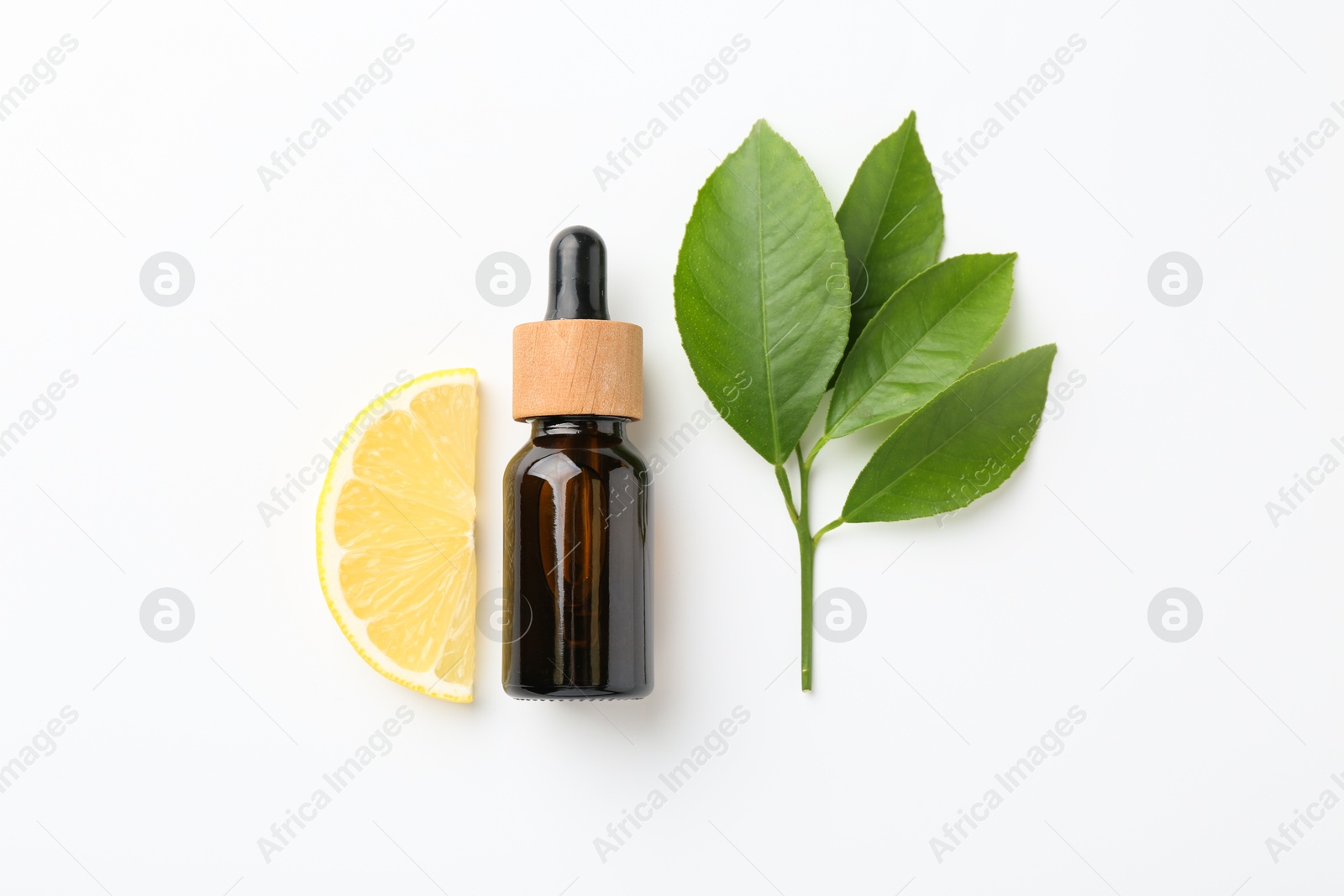 Photo of Bottle of essential oil, lemon and green leaves on white background, flat lay