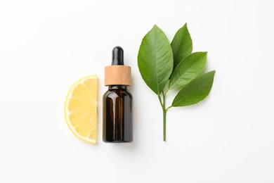 Photo of Bottle of essential oil, lemon and green leaves on white background, flat lay