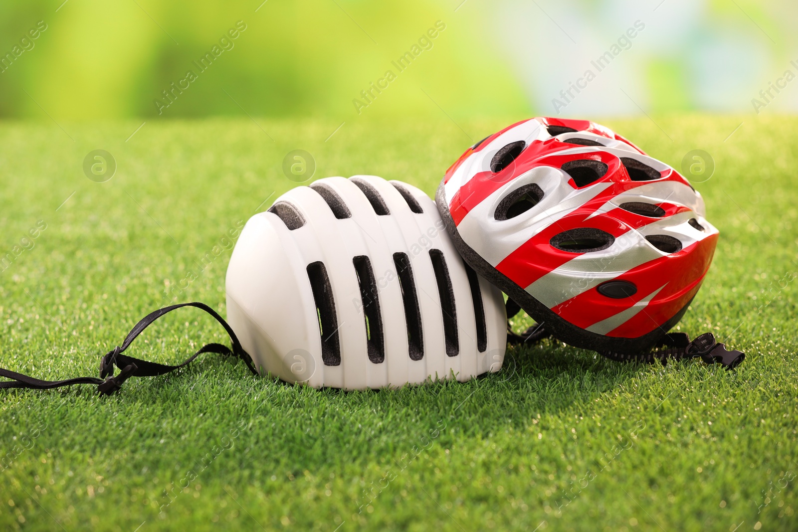 Photo of Two protective helmets on green grass. Sports equipment