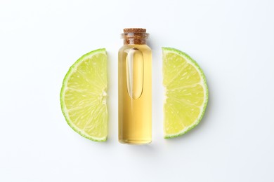 Bottle of essential oil and lime on white background, flat lay