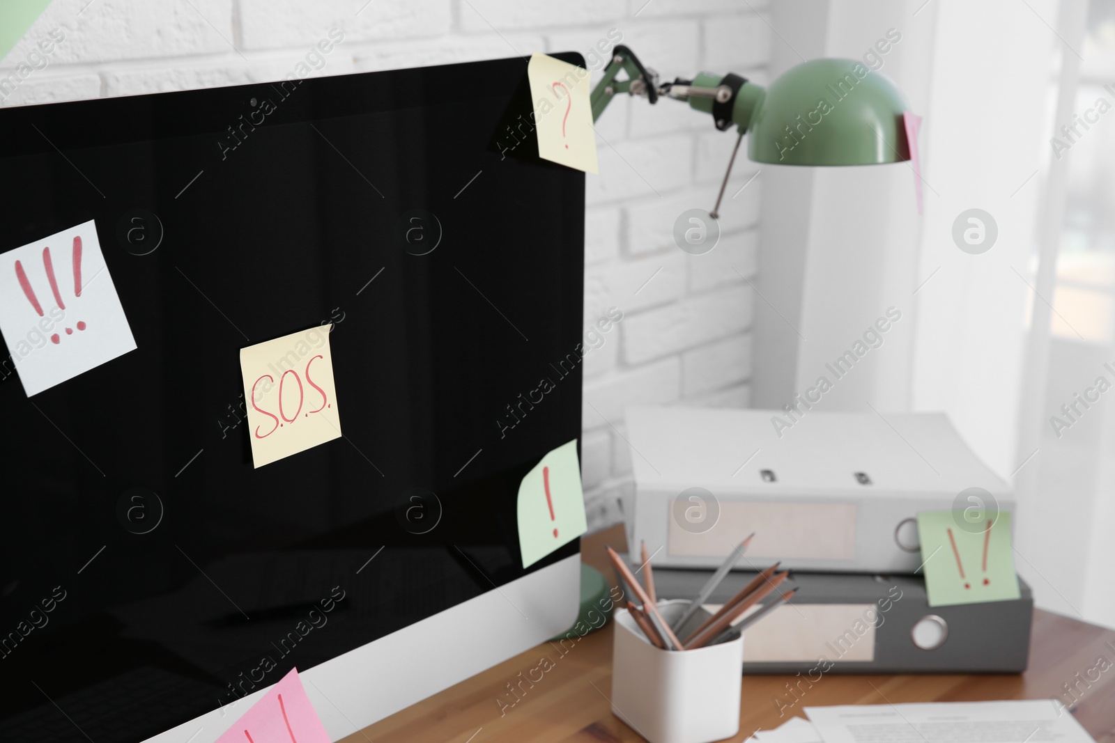 Photo of Notes with word SOS and symbols on computer at workplace