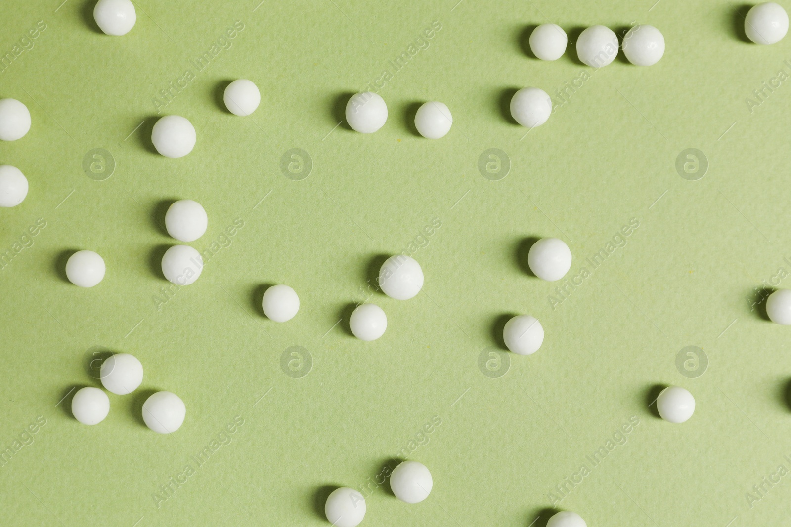 Photo of Homeopathic remedy on light green background, flat lay