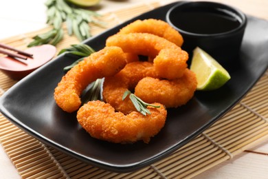 Photo of Tasty breaded fried shrimps served on light wooden table, closeup