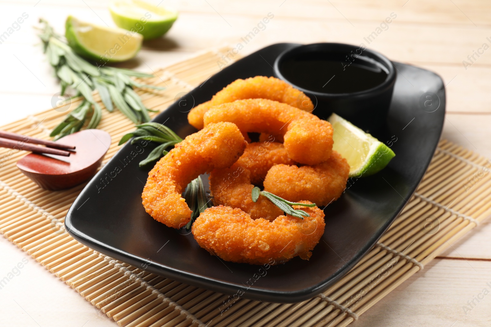 Photo of Tasty breaded fried shrimps served on light wooden table