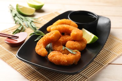 Tasty breaded fried shrimps served on light wooden table