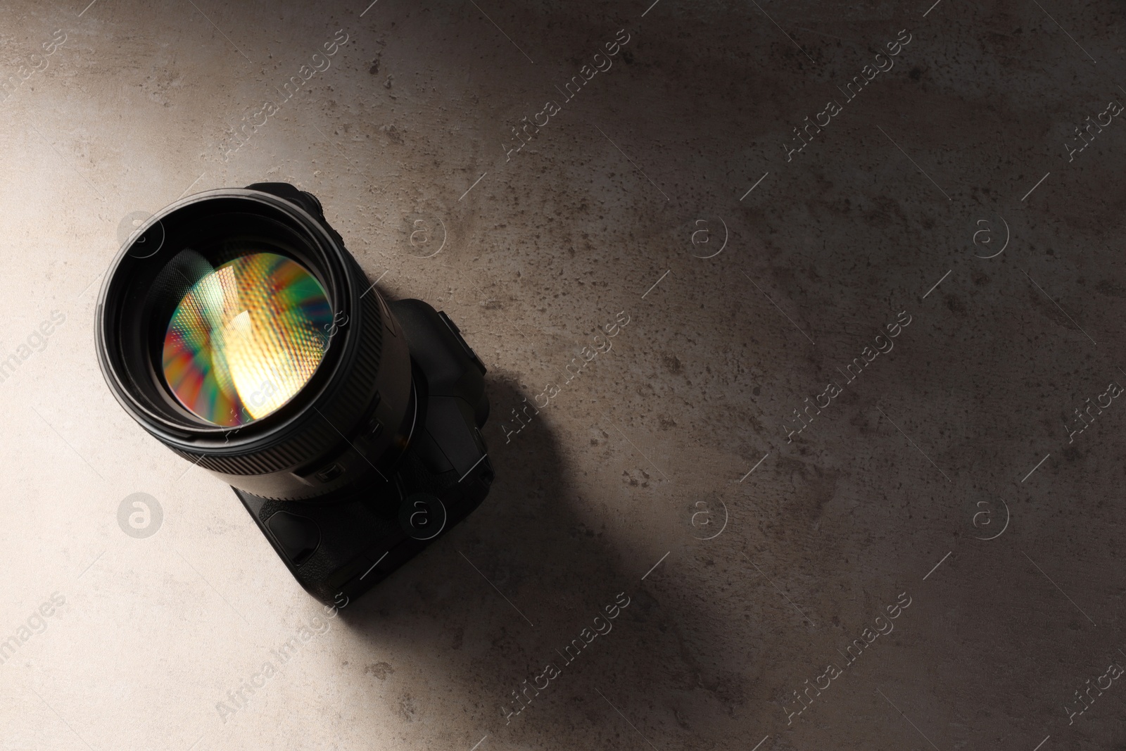 Photo of Modern photo camera on light grey table, above view. Space for text