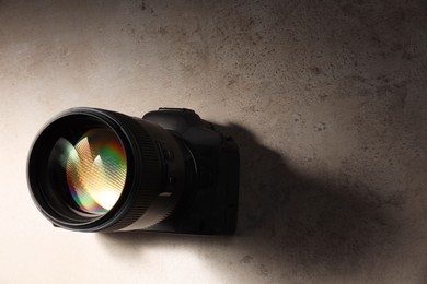 Photo of Modern photo camera on light grey table, above view. Space for text