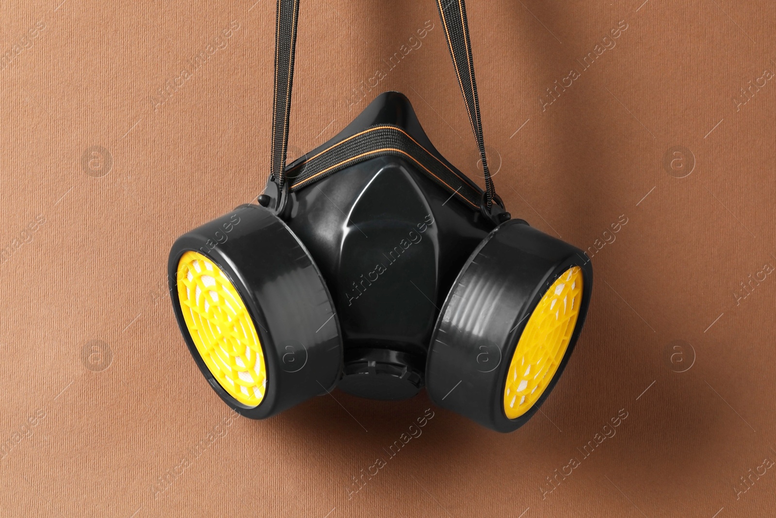 Photo of One respirator mask on brown background. Safety equipment