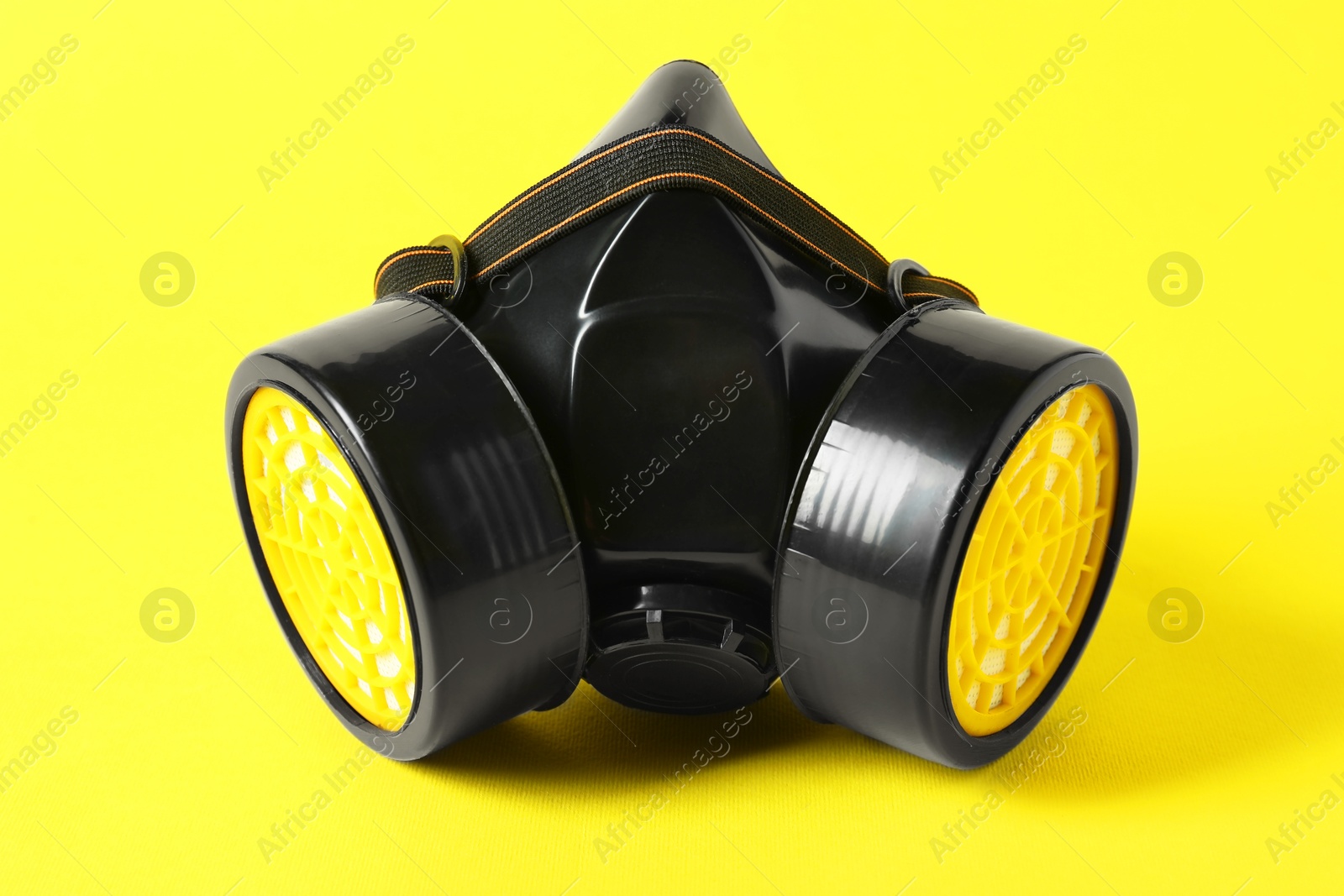 Photo of One respirator mask on yellow background, closeup