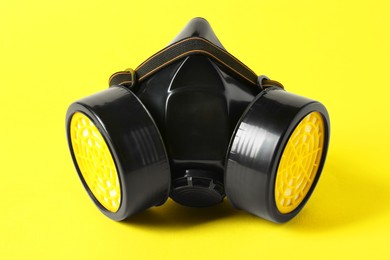 Photo of One respirator mask on yellow background, closeup