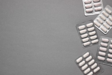 Photo of Different antibiotic pills in blisters on gray background, flat lay. Space for text