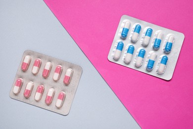 Photo of Different antibiotic pills in blisters on color background, flat lay