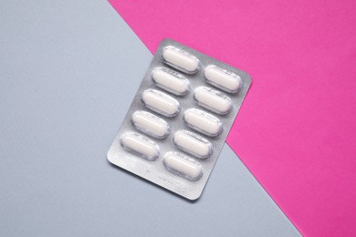 Photo of Antibiotic pills in blister on color background, top view