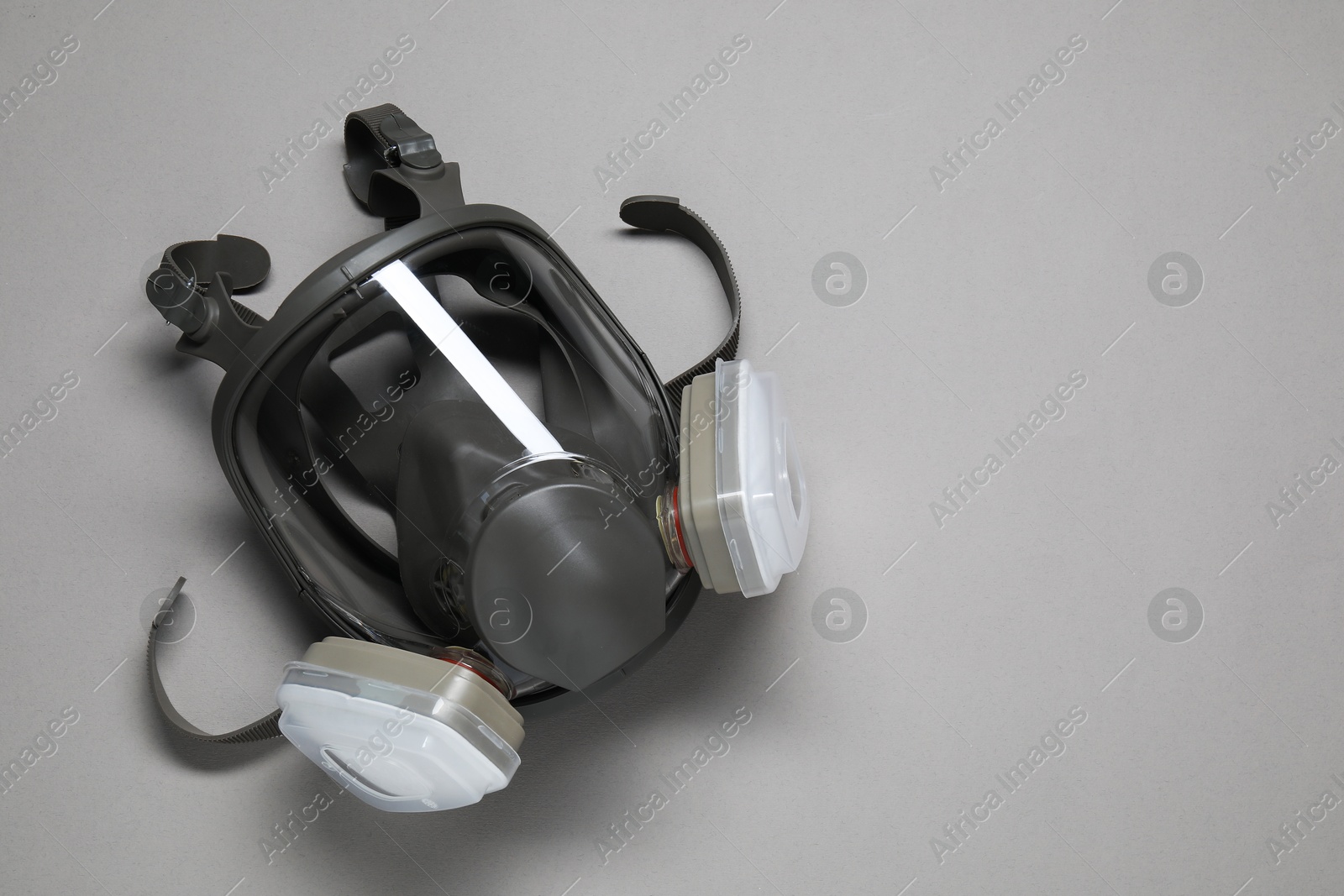 Photo of One full face respirator on grey background, top view. Space for text