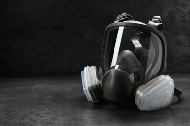 One full face respirator on dark background. Space for text