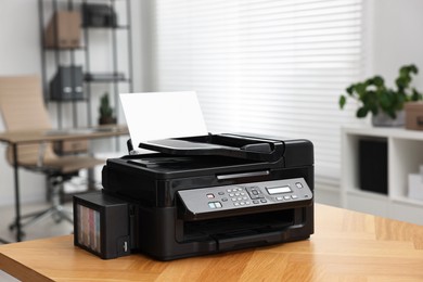 Modern printer with paper on table in office