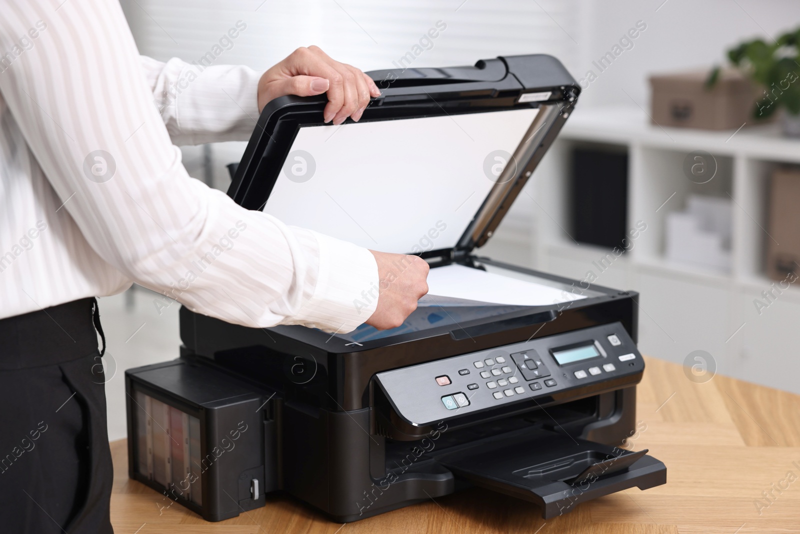 Photo of Woman using modern printer at workplace indoors, closeup