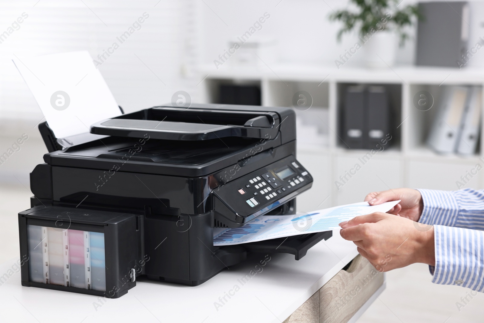 Photo of Woman using modern printer at workplace indoors, closeup