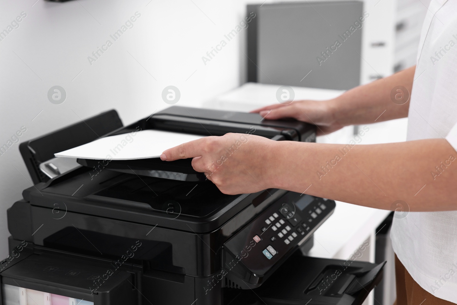 Photo of Woman using modern printer at workplace indoors, closeup