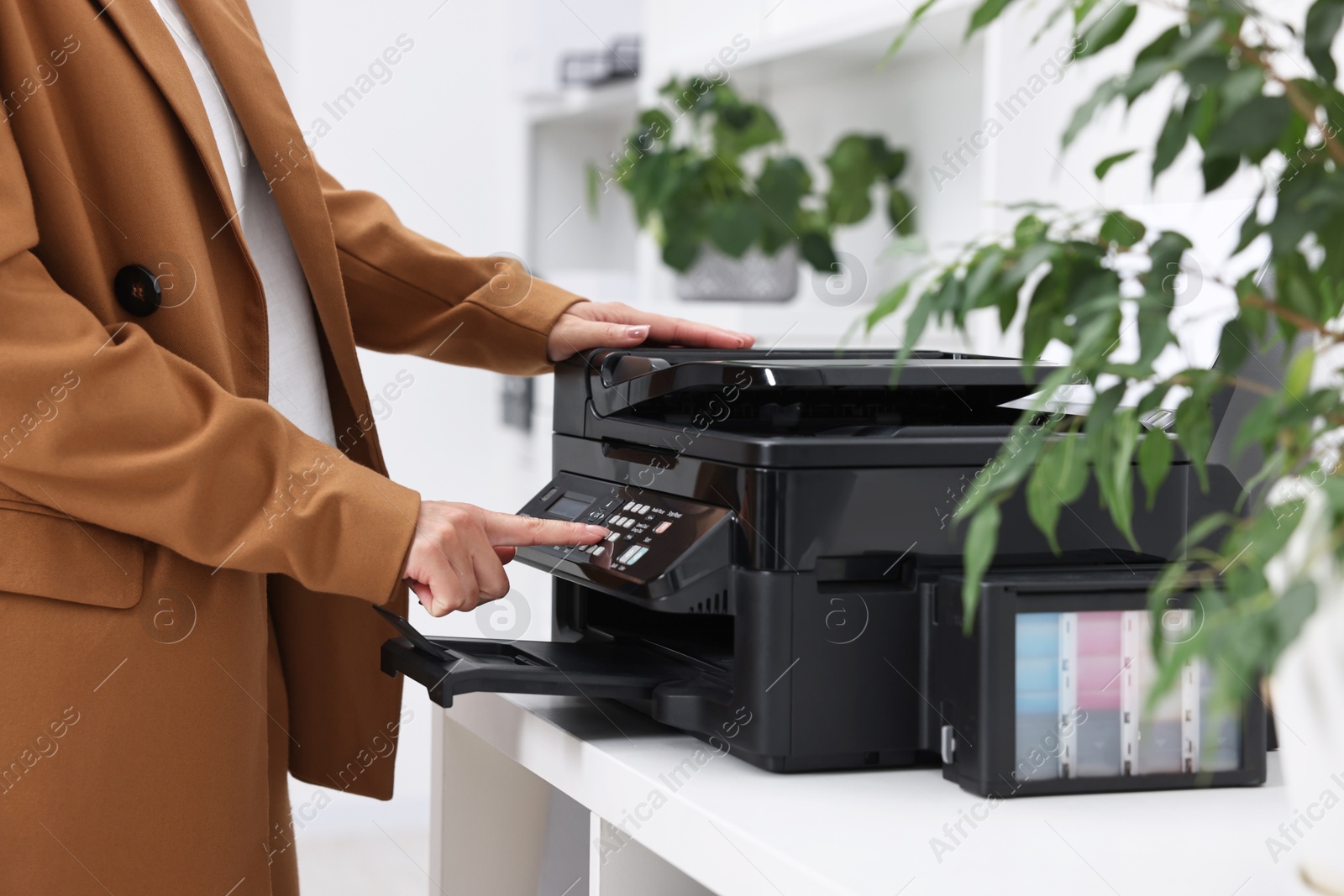 Photo of Woman using modern printer at workplace indoors, closeup