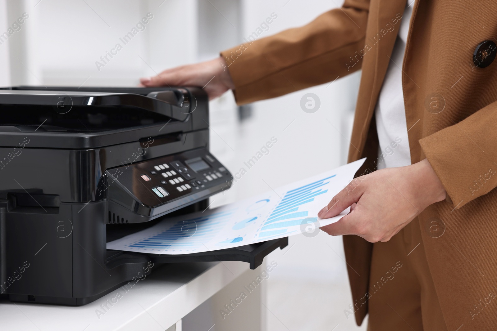 Photo of Woman using modern printer at workplace indoors, closeup