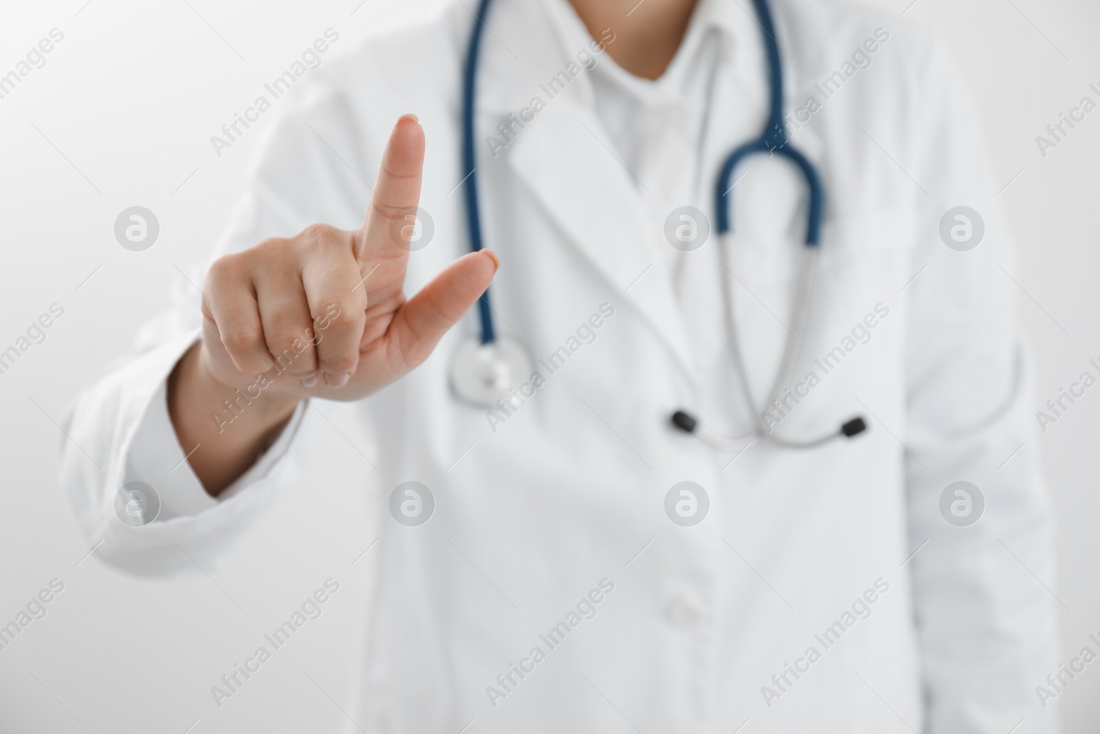 Photo of Doctor pointing at something on white background, closeup