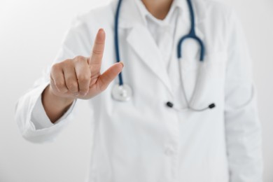 Photo of Doctor pointing at something on white background, closeup