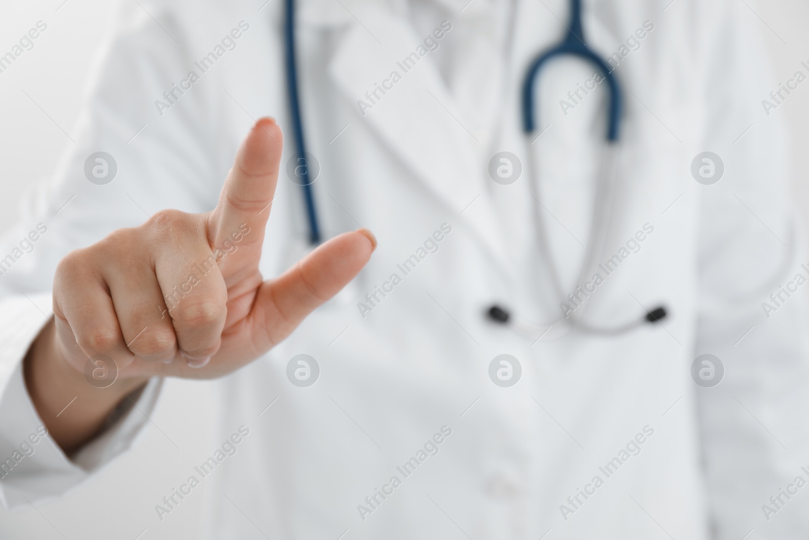 Photo of Doctor pointing at something on white background, closeup