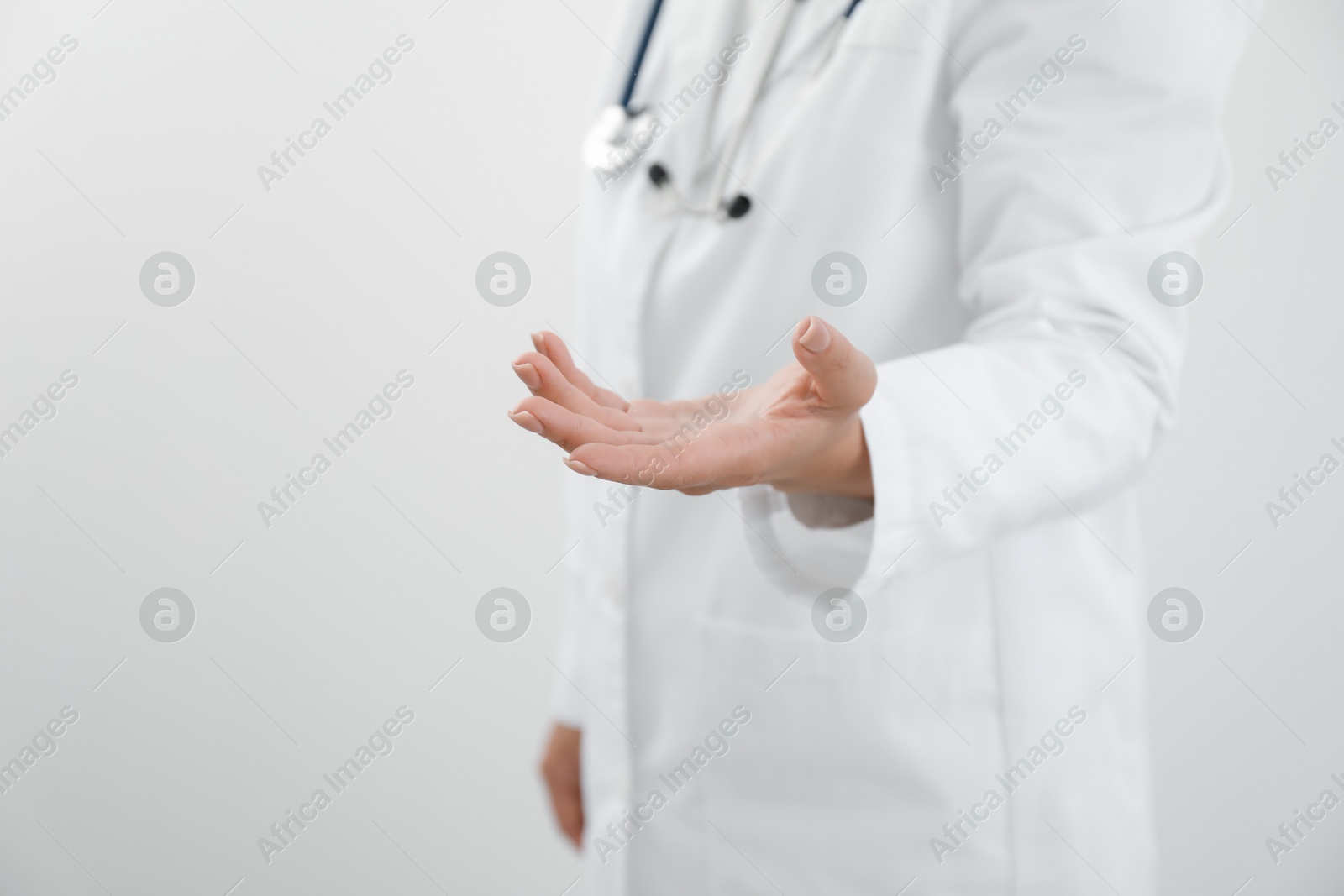 Photo of Doctor holding something on white background, closeup. Space for text