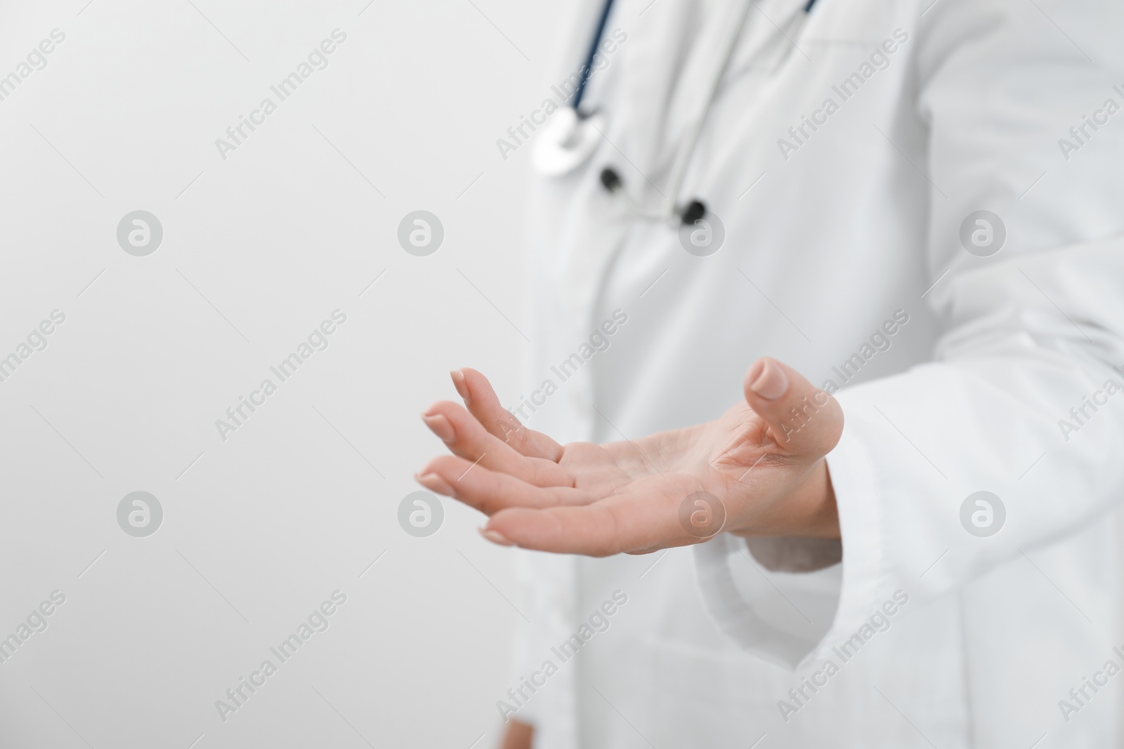 Photo of Doctor holding something on white background, closeup. Space for text