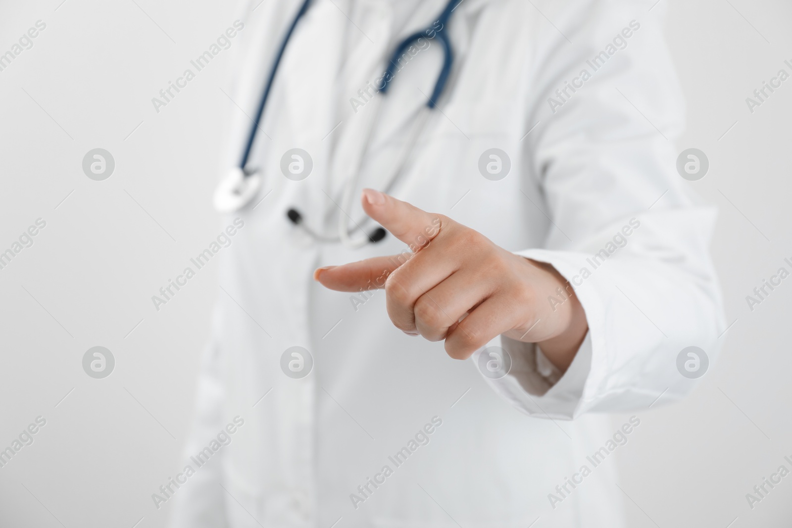 Photo of Doctor pointing at something on white background, closeup